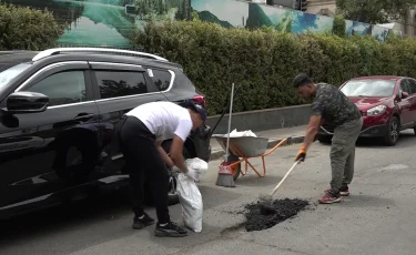 Таза Қазақстан: Алматыда экобелсенділер жолды тегістеп, шұңқырларды бітеді