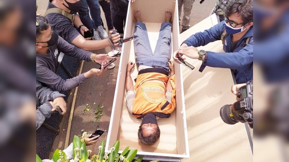 В Индонезии нарушителей карантина возят на катафалках и укладывают в гроб