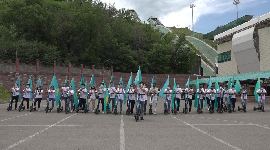 На электросамокатах по улицам города: Алматинская молодежь подняла флаг Казахстана